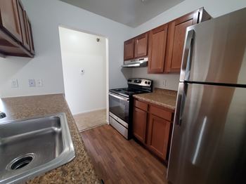 A kitchen with a stainless steel refrigerator, sink, and stove.